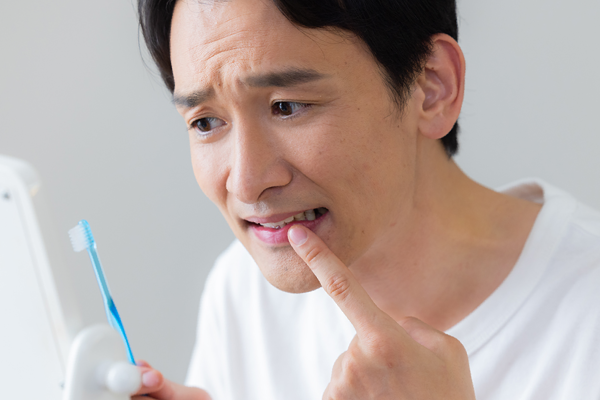 前歯の色に悩む男性